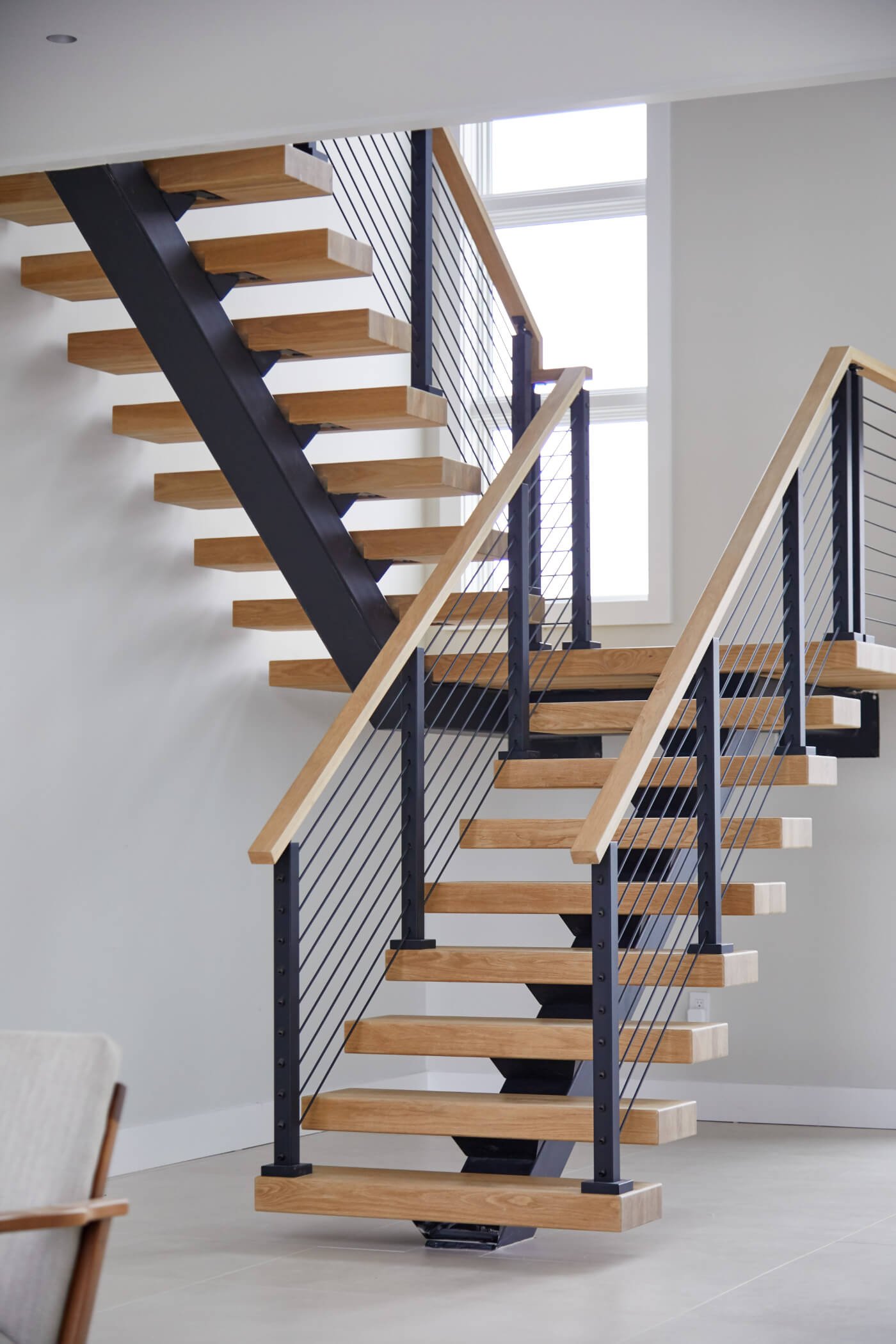 Straight floating staircase connecting a modern duplex home